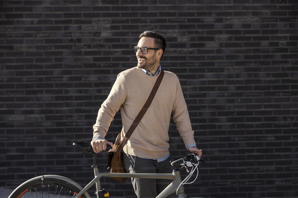 An urban commuter pushing bicycle on the street.