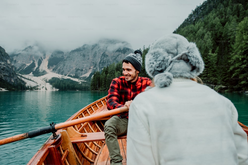 Coppia romantica su una barca che visita un lago alpino a Braies Italia. Turista innamorato che trascorre momenti d'amore insieme in montagna d'autunno. Concetto di viaggio, coppia e vagabondaggio.