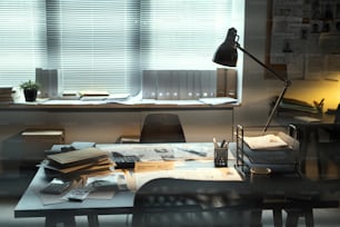 Lamp lighting workplace of contemporary FBI agent with criminal profiles, stacks of journals, documents and other supplies