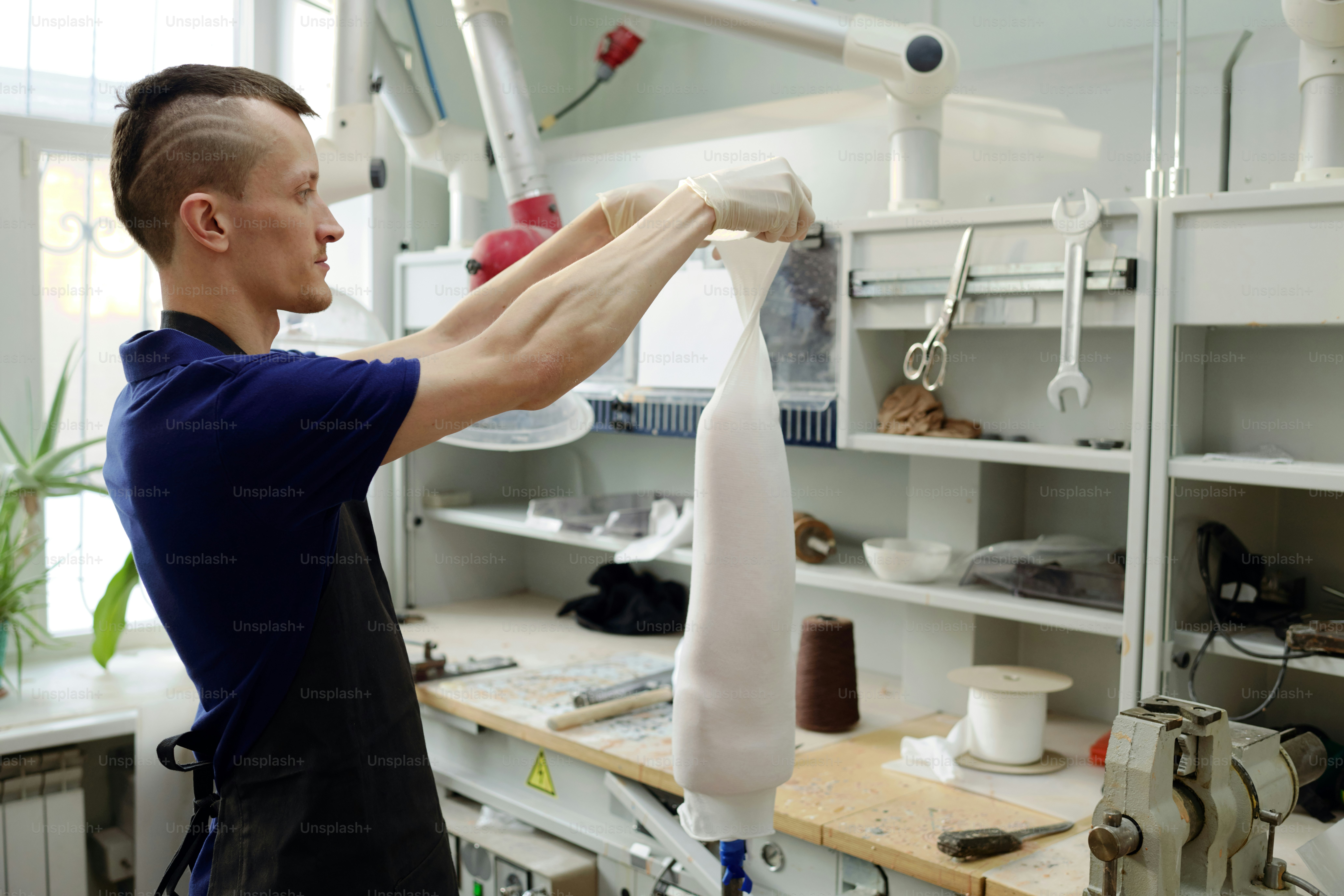 Worker of modern prosthetic production factory assembling new ...