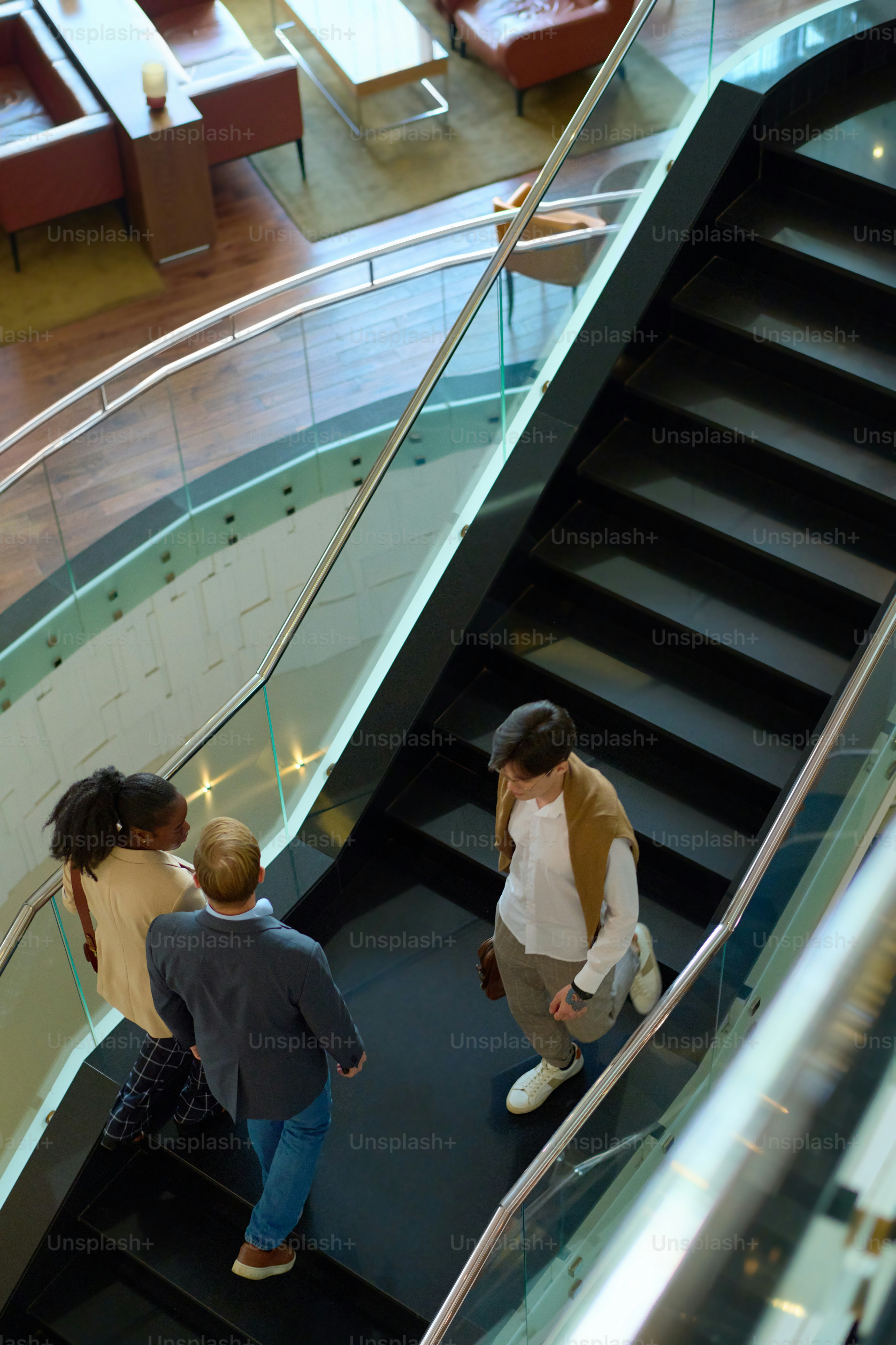 Au-dessus de l’angle des gens d’affaires se déplaçant à l’étage et en bas le long de l’escalier situé au premier étage d’un hôtel moderne et luxueux