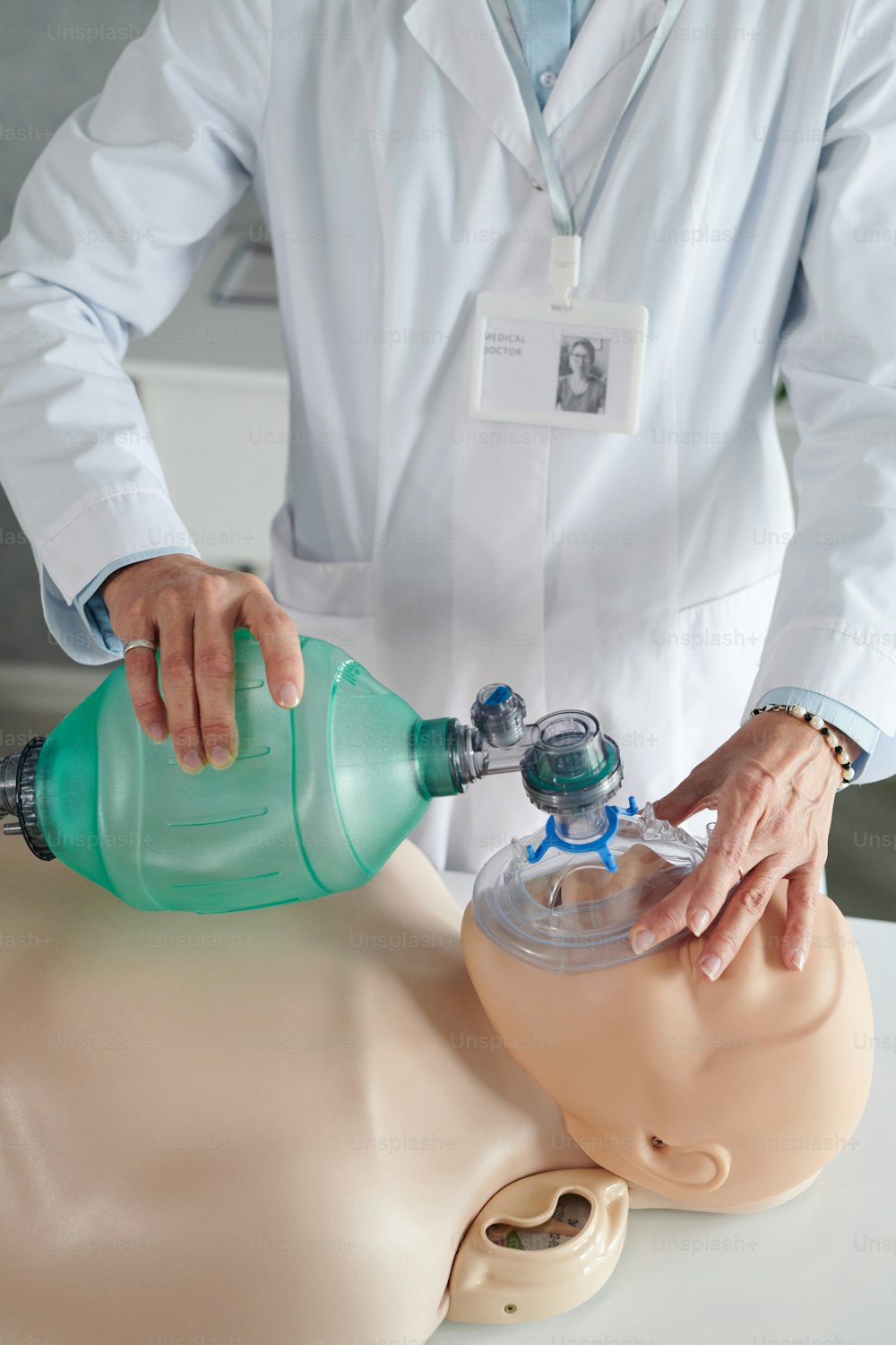 Close-up of paramedic in white coat using oxygen mask to make first aid during medical course