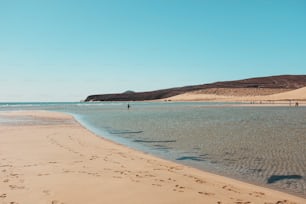 Summer holiday vacation travel concept. Sandy beach and blue clean ocean water with tourists. Tropical beautiful scenic place. Blue sky in background.