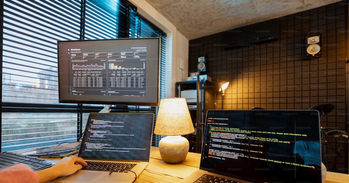 Female programmer writing programming code on laptops and desktop ...