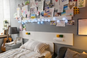 Bild von gemalten Bildern von Patienten, die an der Wand hängen, mit bequemem Bett, das unter ihnen in der Krankenstation steht