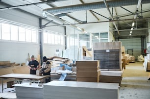 Image of big warehouse of furniture production with workers working in team