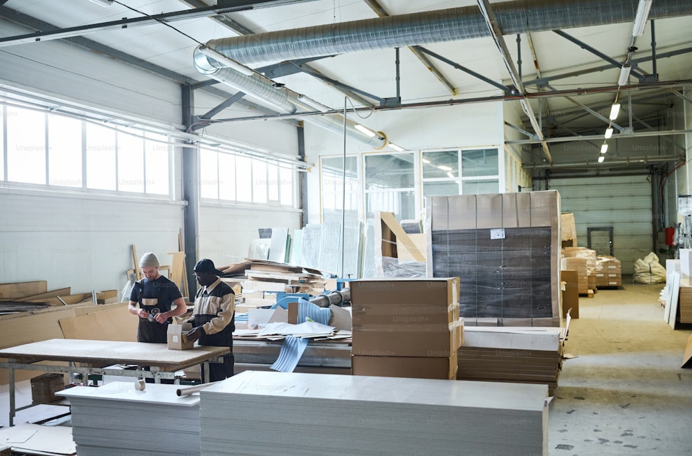 Image of big warehouse of furniture production with workers working in team