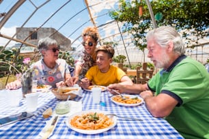 nice leisure activity outdoor in natural bio restaurant for nice beautiful caucasian family with all generations from young to old. mother, son, grandfathers all together enjoying
