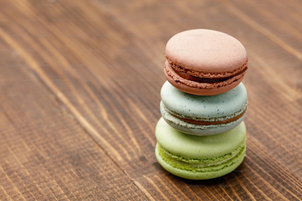 Chocolate Macarons On Wooden Table. Close Up French Macaroons Still Life. High Resolution