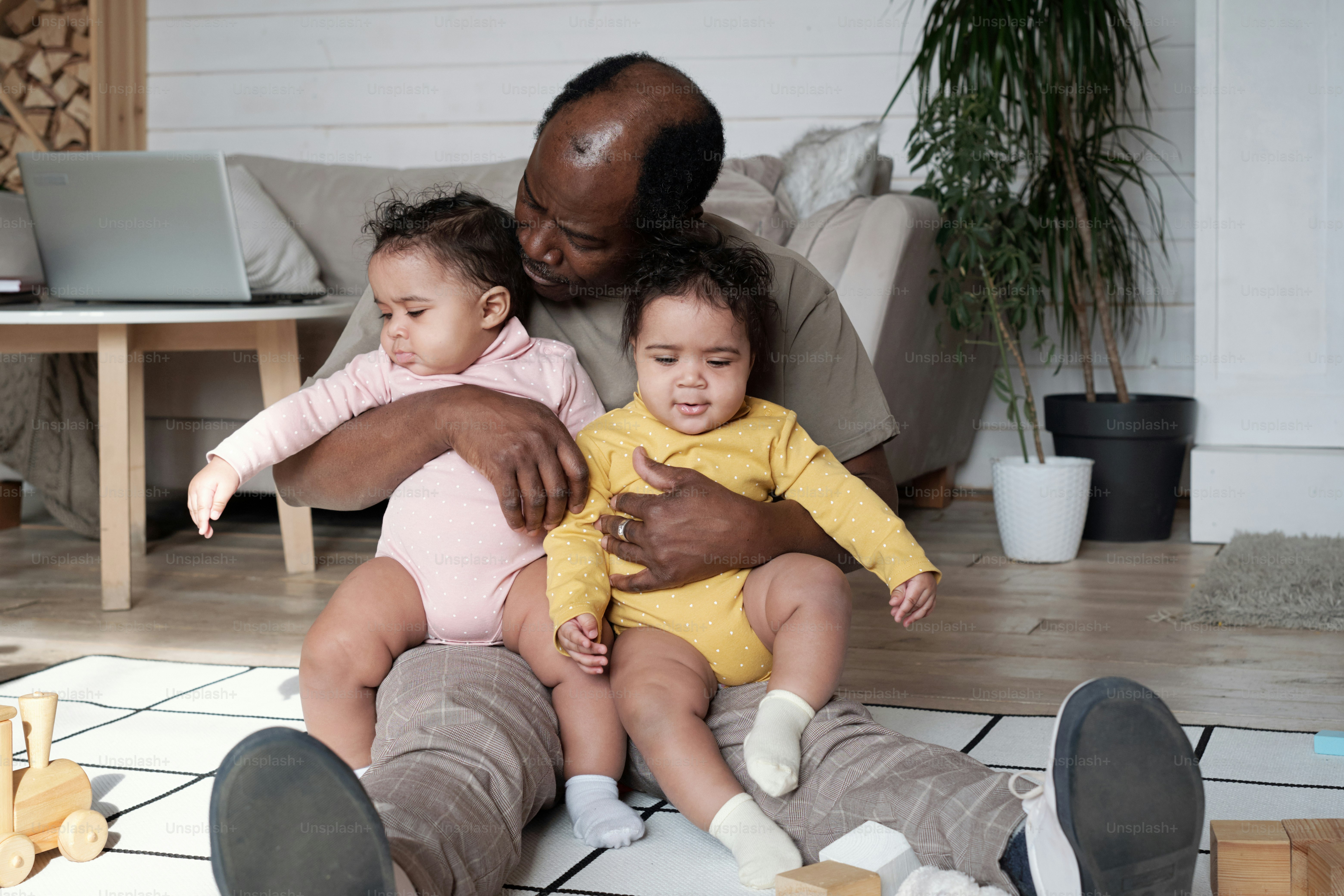 Père afro-américain heureux assis sur le sol dans un salon confortable à la  maison embrassant ses filles jumelles photo – Image de Famille sur Unsplash, image size:3000x2000