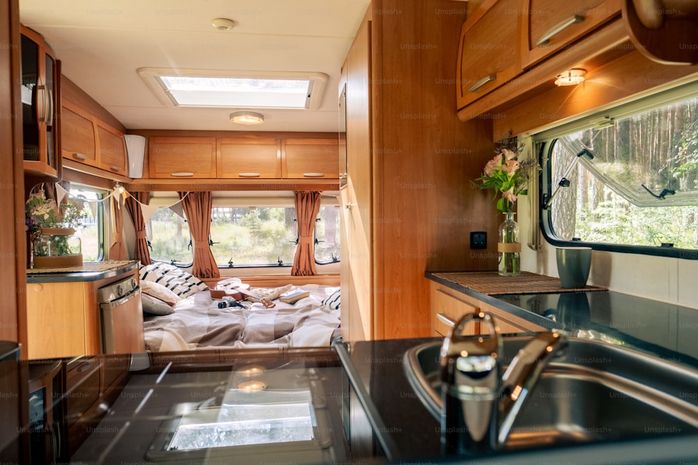 Part of bedroom and kitchen inside spacious house on wheels