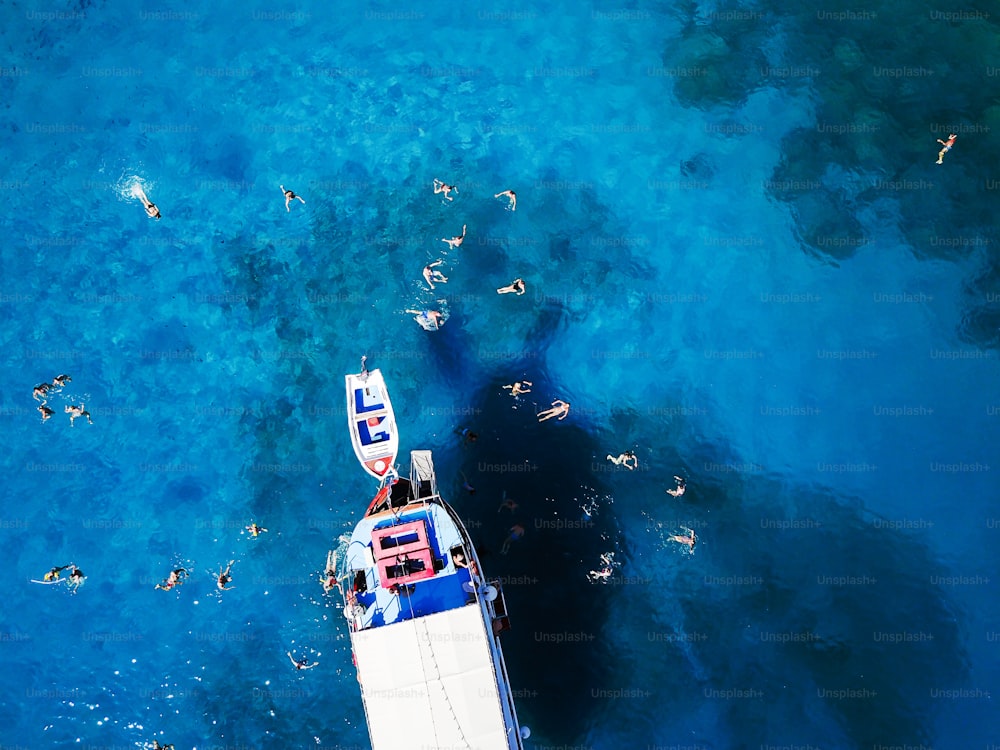 Veduta aerea dei turisti che nuotano in una splendida acqua di mare limpida.