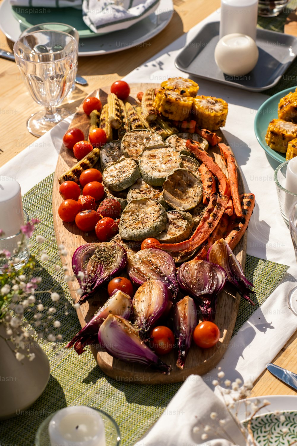 Tasty grilled vegetables like zuccini, carrots, red onions and tomatoes on big board