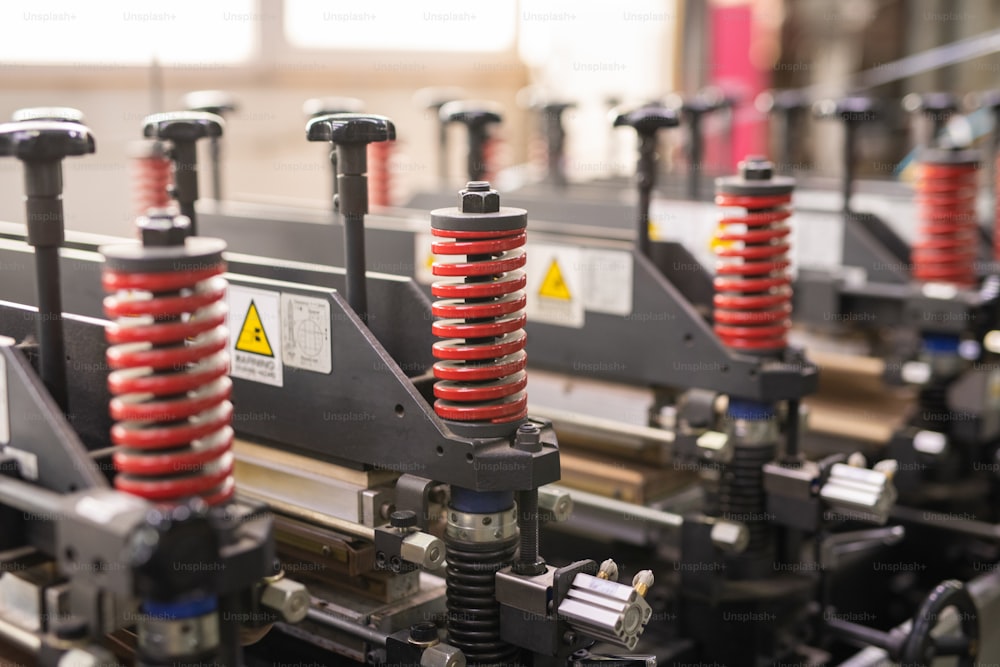 化学生産工場のワークショップにおける現代の産業または技術機器の赤い螺旋状の詳細の列