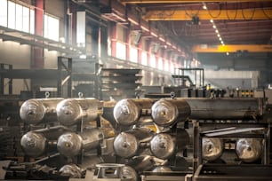 Steel or metal industrial equipment or parts of large machines inside warehouse or factory workshop
