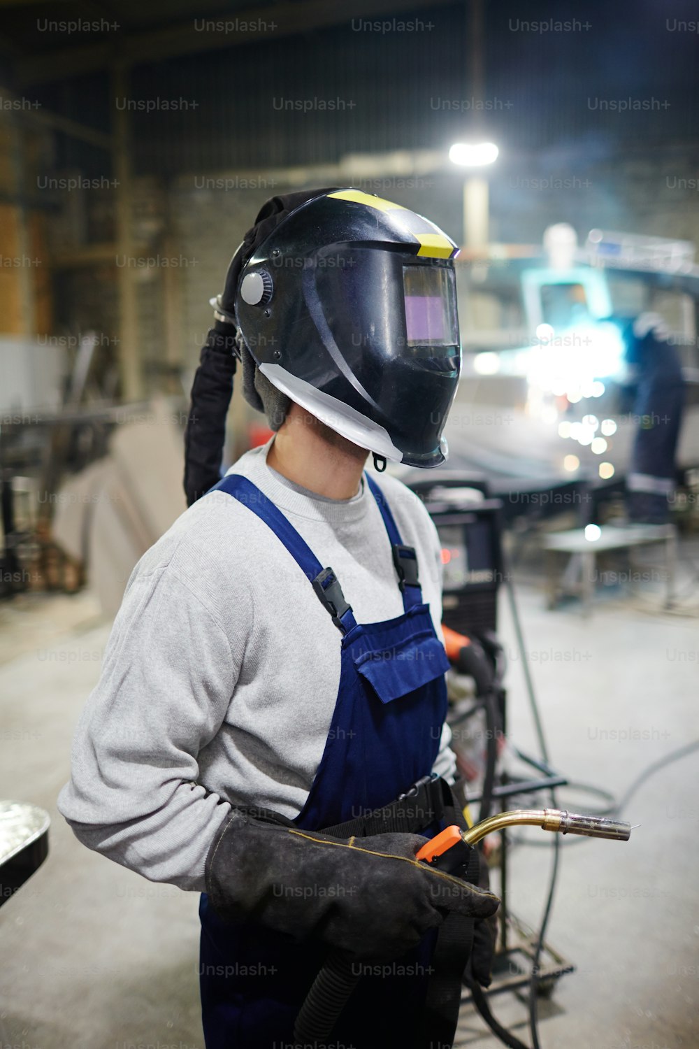 Contemporary shipbuilding engineer in protective workwear going to carry out welding work