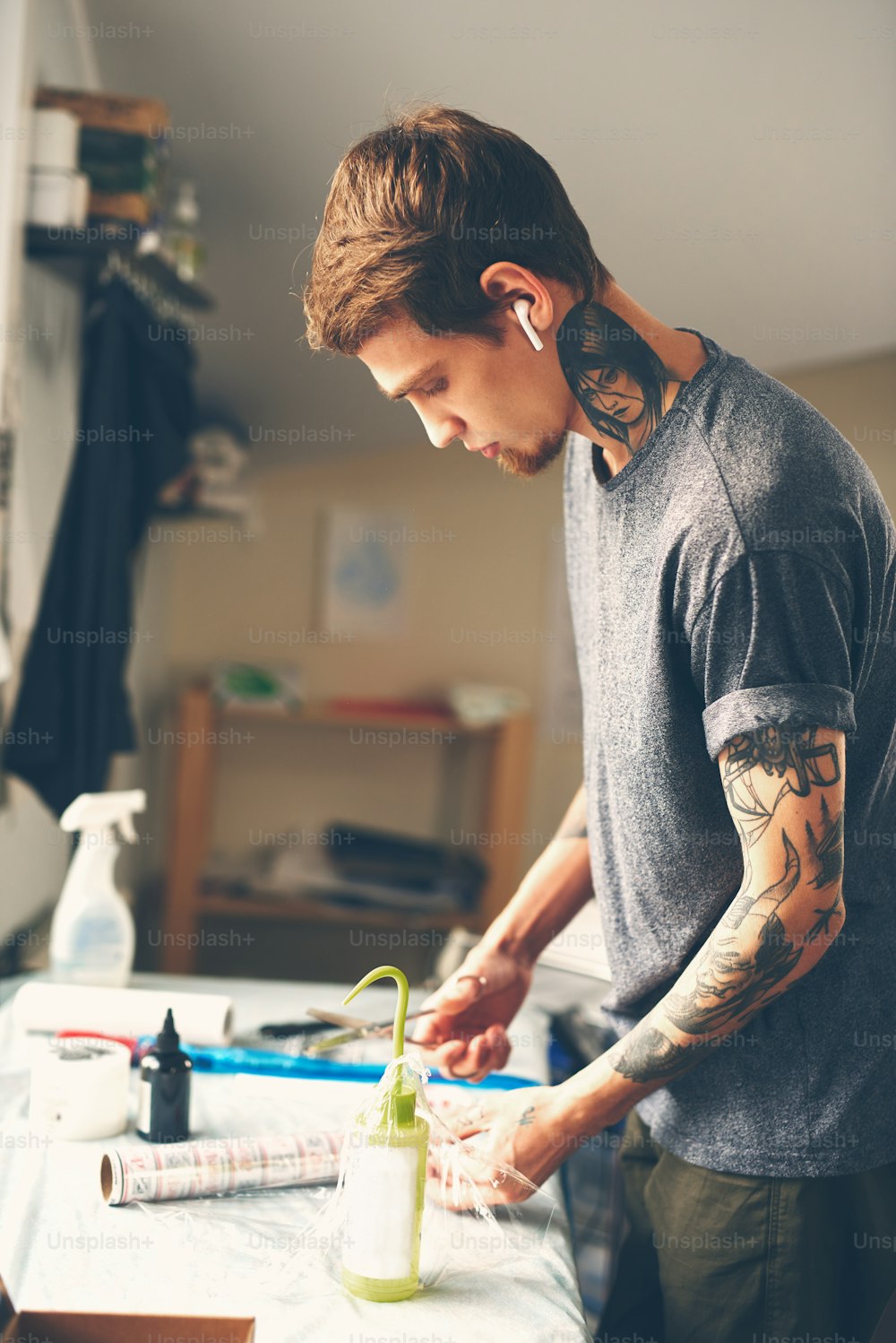 A young guy, a tattoo artist preparing for the session, prepares the tools and ink for tattoo