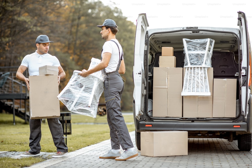 貨物車を降ろし、商品や家具を顧客の家に配達する配送会社の従業員。リロケーションとプロフェッショナルな配送のコンセプト