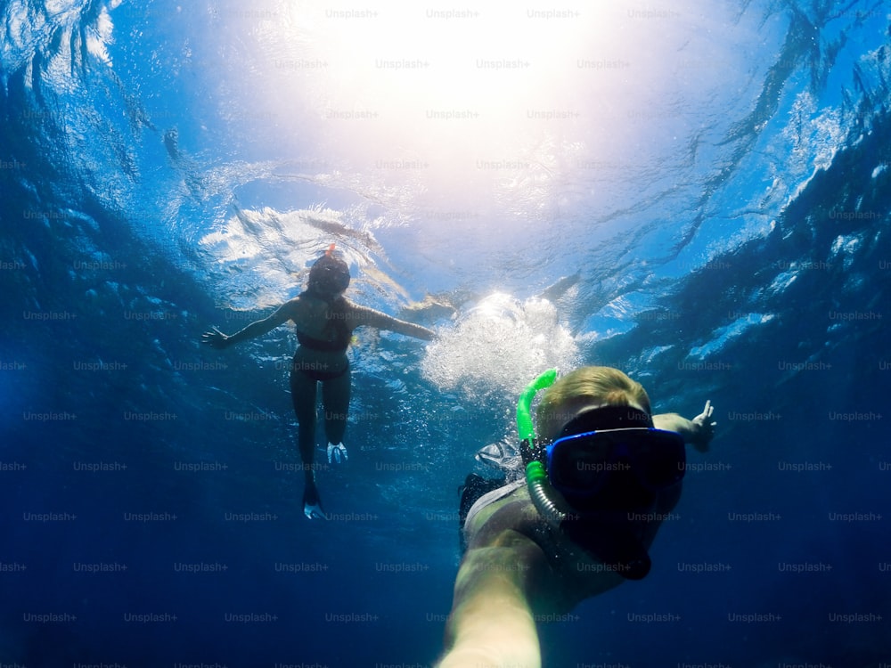Casal snorkeling no mar azul profundo. Diversão de verão. Tirar selfie debaixo d'água.