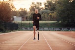 Un sportif en forme avec une jambe artificielle qui court au stade.