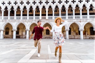 Casal romântico apaixonado correndo na cidade de Veneza, Itália. Homem e mulher em férias na Itália desfrutando de tempo juntos.