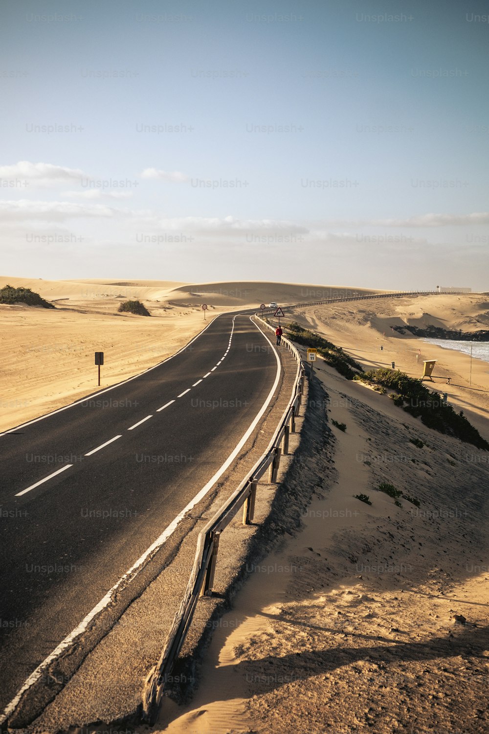 Long black way road in the desert with beautiful beach on the side - concept of travel and summer adventure alternative vacation in tropical beautiful scenic place - blue sky in background