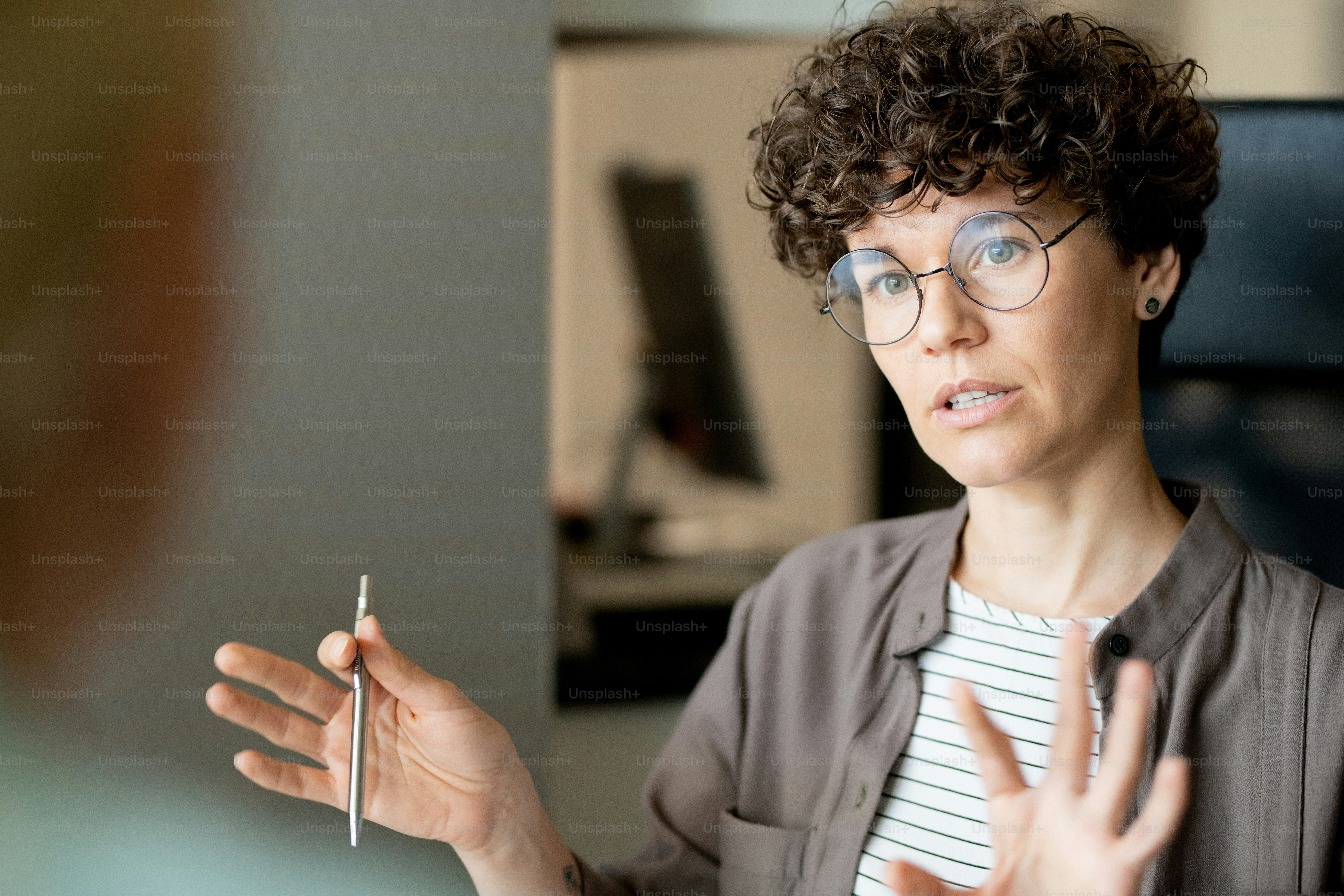 Young confident teacher or business agent consulting client at meeting or student at individual lesson