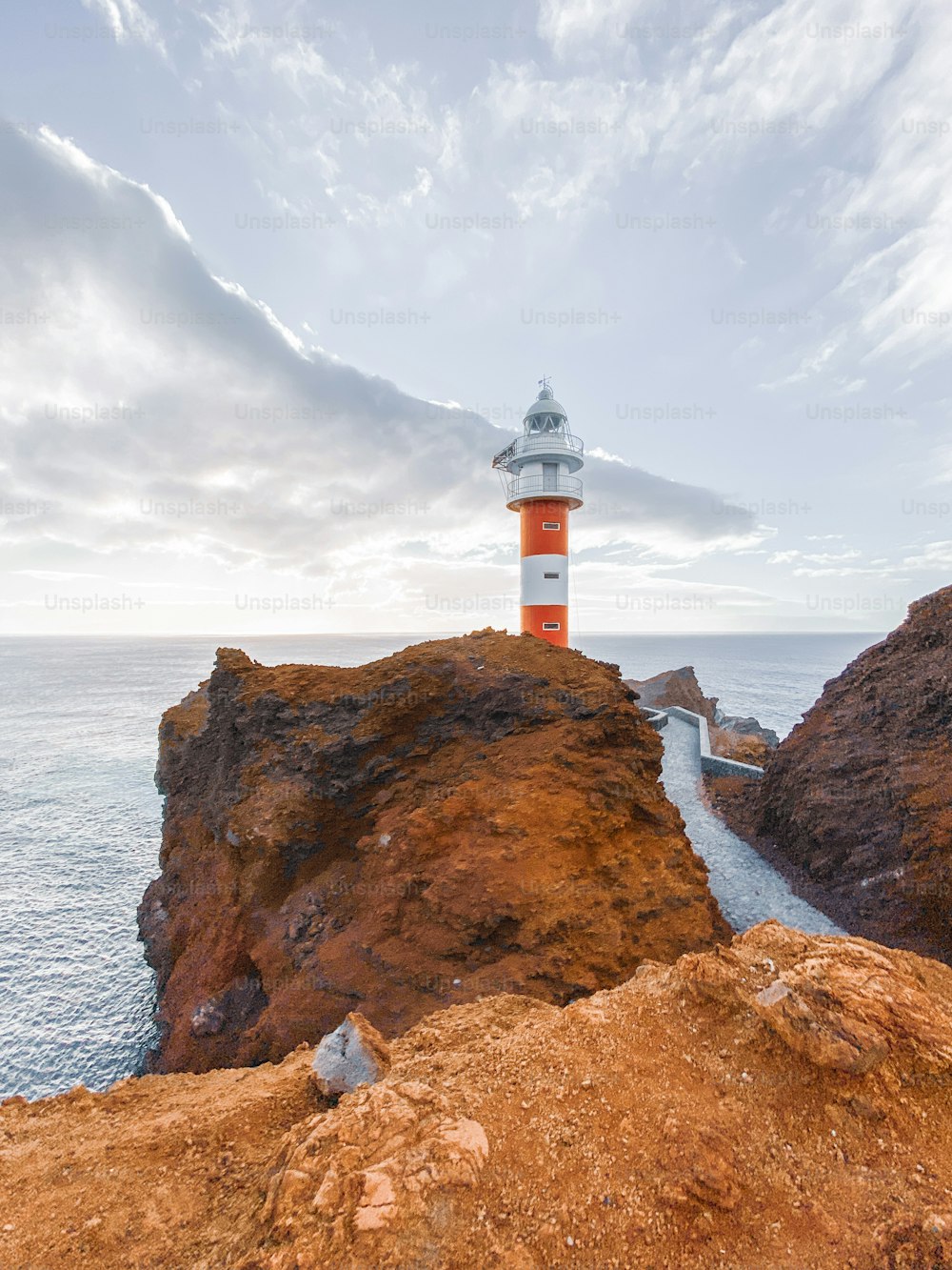 Beautiful landscape on a rocky coast with lighthouse during a sunset. Image made on mobile phone