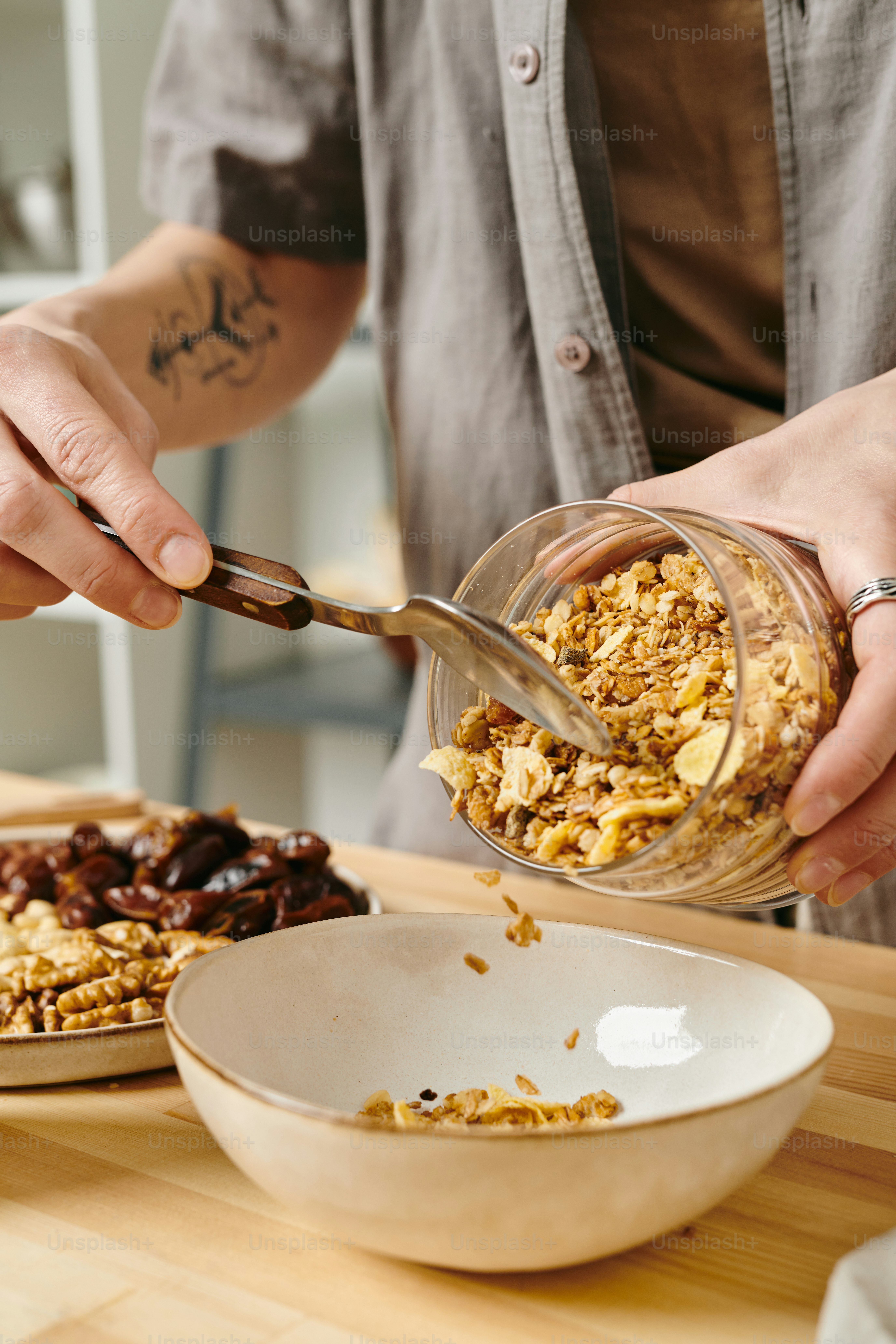 Manos de mujer poniendo un poco de muesli en un cuenco mientras prepara el desayuno