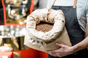 Barista holding bag full with roasted coffee beans at the coffee store