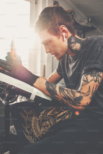 Foto Un chico joven, golpea un tatuaje en la mano de la chica en un salón  de tatuajes, máquina de tatuaje rotativa, tinta negra, destello de lente –  Tatuaje Imagen en Unsplash
