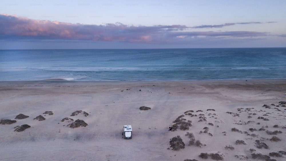 Camper van in outdoors alone camp site enjoy freedom and sunset with ocean and sky view. Concept of travel and adventure. Summer holiday vacation with modern camping car parked on the sand