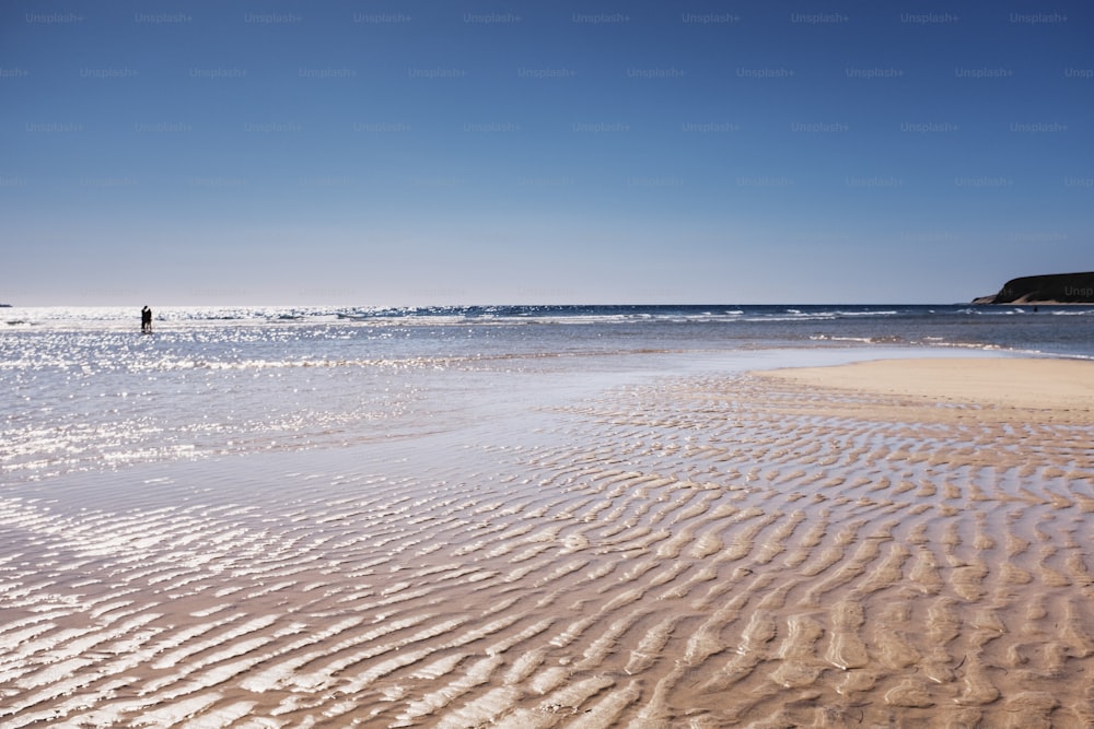 Coppia che si gode la spiaggia di sabbia e il cielo e l'acqua blu dell'oceano durante le vacanze estive. Concetto di viaggio, stile di vita e persone insieme. Giornata di sole con il mare sullo sfondo