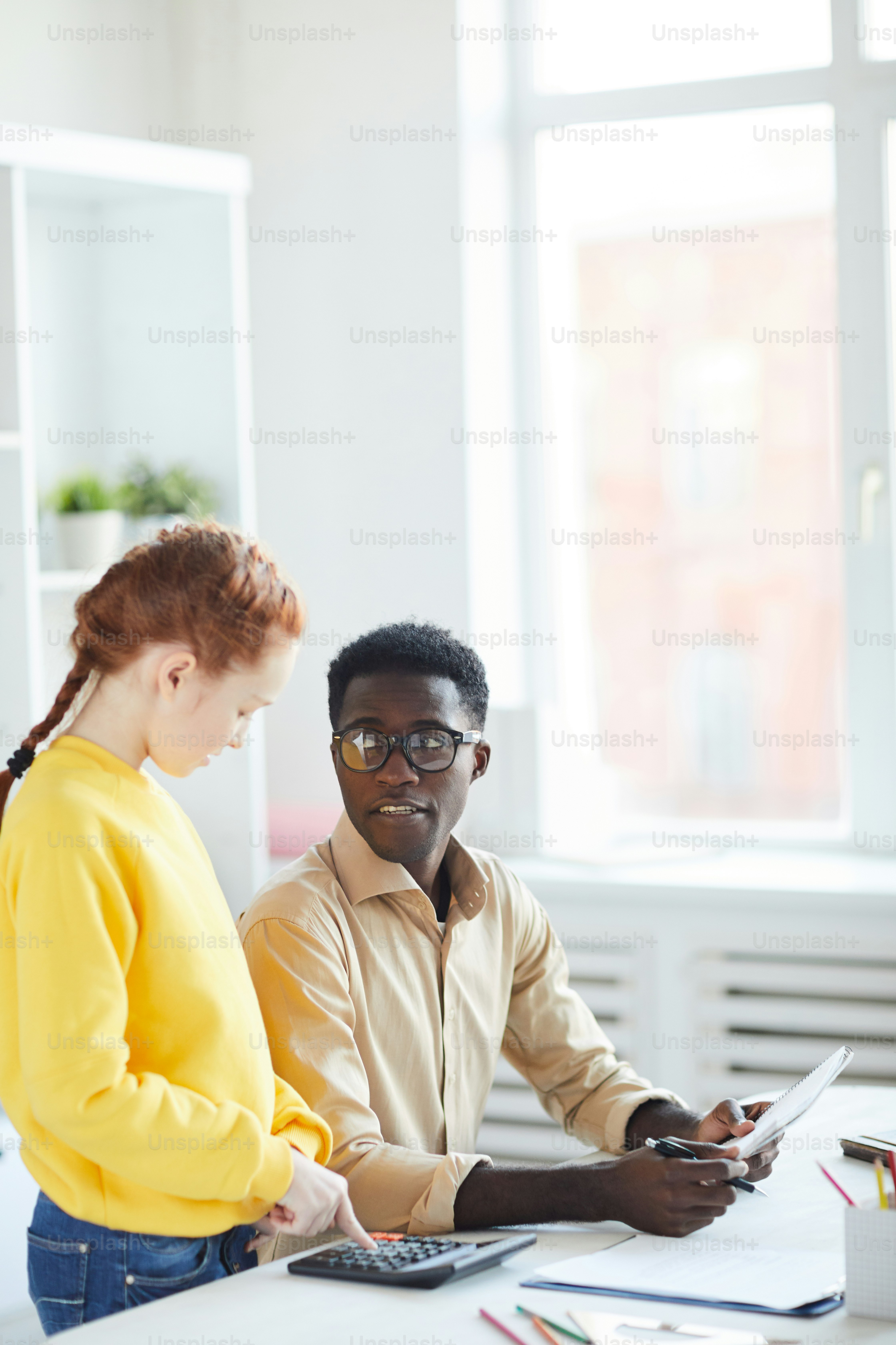 Un profesor de escuela afroamericano y uno de sus alumnos discuten algunos puntos débiles de la lección