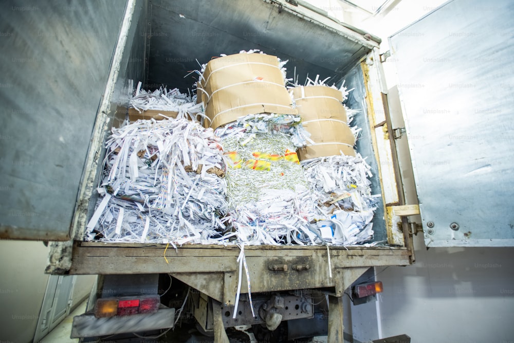 Puerta abierta del camión con pila de papel cortado envuelto en dibujos animados, concepto de logística