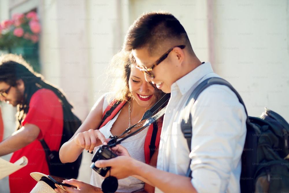 Multiracial couple exploring a city, happy tourists discovering new locations looking at camera..