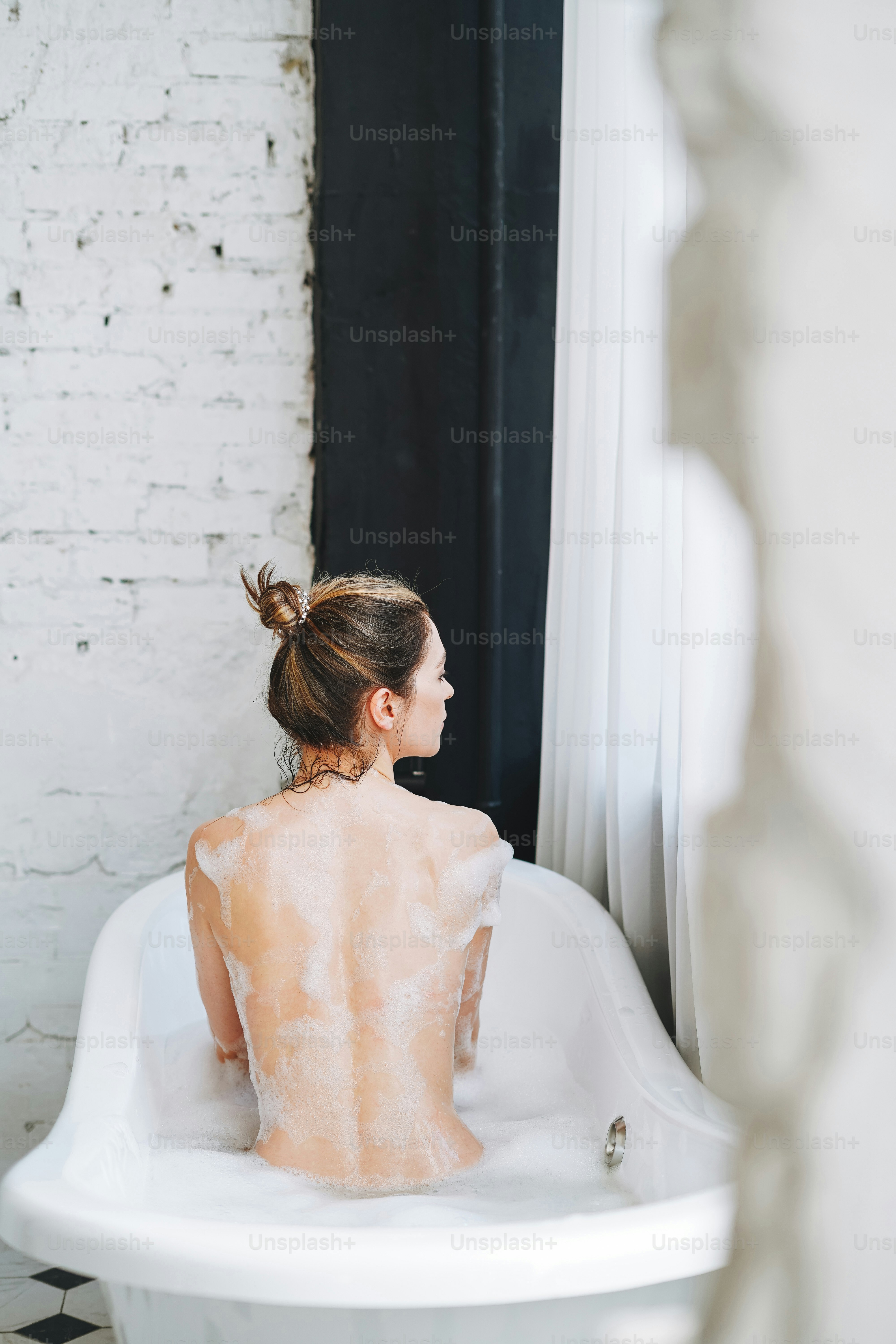 Joven mujer feliz tomando baño con espuma en casa, date un capricho