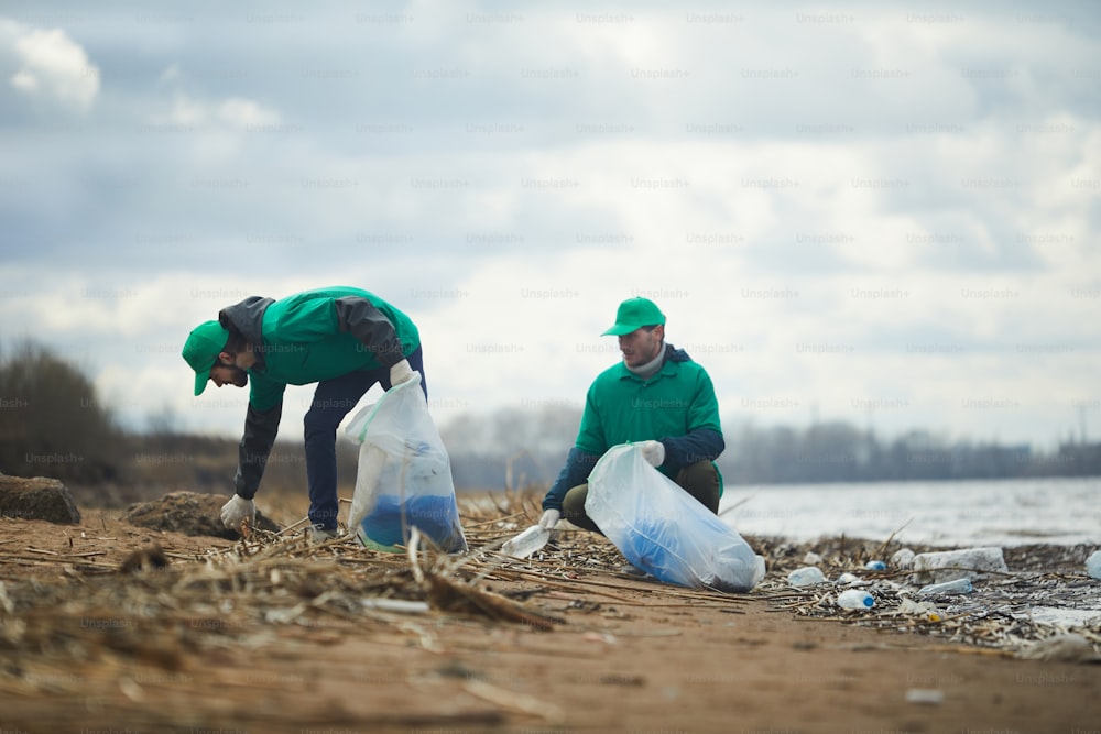 Arbeiter der Ökologieorganisation sammeln Müll aus schmutzigem Gebiet und verwenden ihn in speziellen Säcken