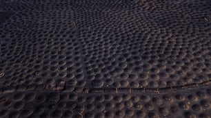 Paisagem padrão com muitos buracos para produzir vinho em solo de areia preta vulcânica. Vista aérea de paisagem alternativa. La Geria Lanzarote produções de vinho negócios agrícolas