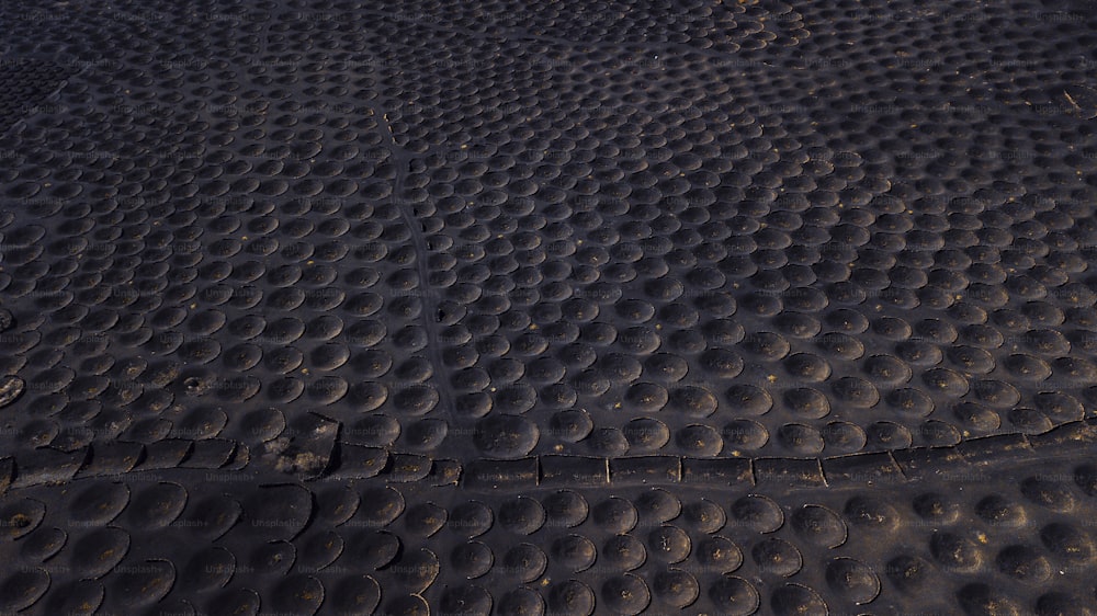 Pattern landscape with many holes to produce wine in volcanic black sand ground. Aerial view of alternative landscape. La Geria Lanzarote wine productions agriculture business