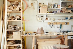 Banco da lavoro del falegname con assortimento di pezzi in legno, cassetta degli attrezzi e altre attrezzature