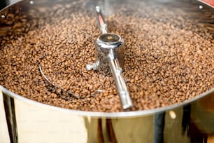 Vista de perto sobre os grãos de café torrados que se refrescam na máquina de torrefação