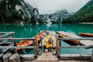 イタリアのブレイズの高山湖を訪れるボートのロマンチックなカップル。秋の山で一緒に愛する瞬間を過ごす恋の観光客。旅行、カップル、放浪についてのコンセプト。