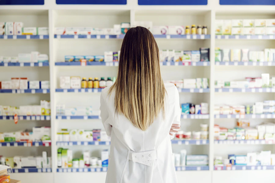 Pharmacist working in front of a stocked dispensary