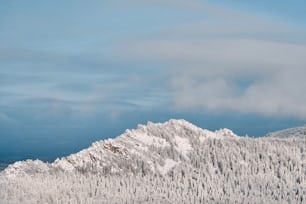 Paisaje invernal de la cadena montañosa de Taganay cubierto de nieve y nubes contra el cielo azul