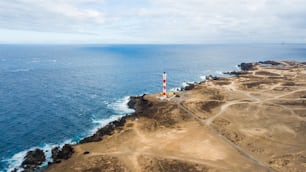 Luftbild des Leuchtturms an der Küste, um das Licht auf den Ozean für Schiffe zu machen. Viele Straßen, um überall hinzugehen und Orte in der Wüste zu entdecken. Travel Adventure Konzept