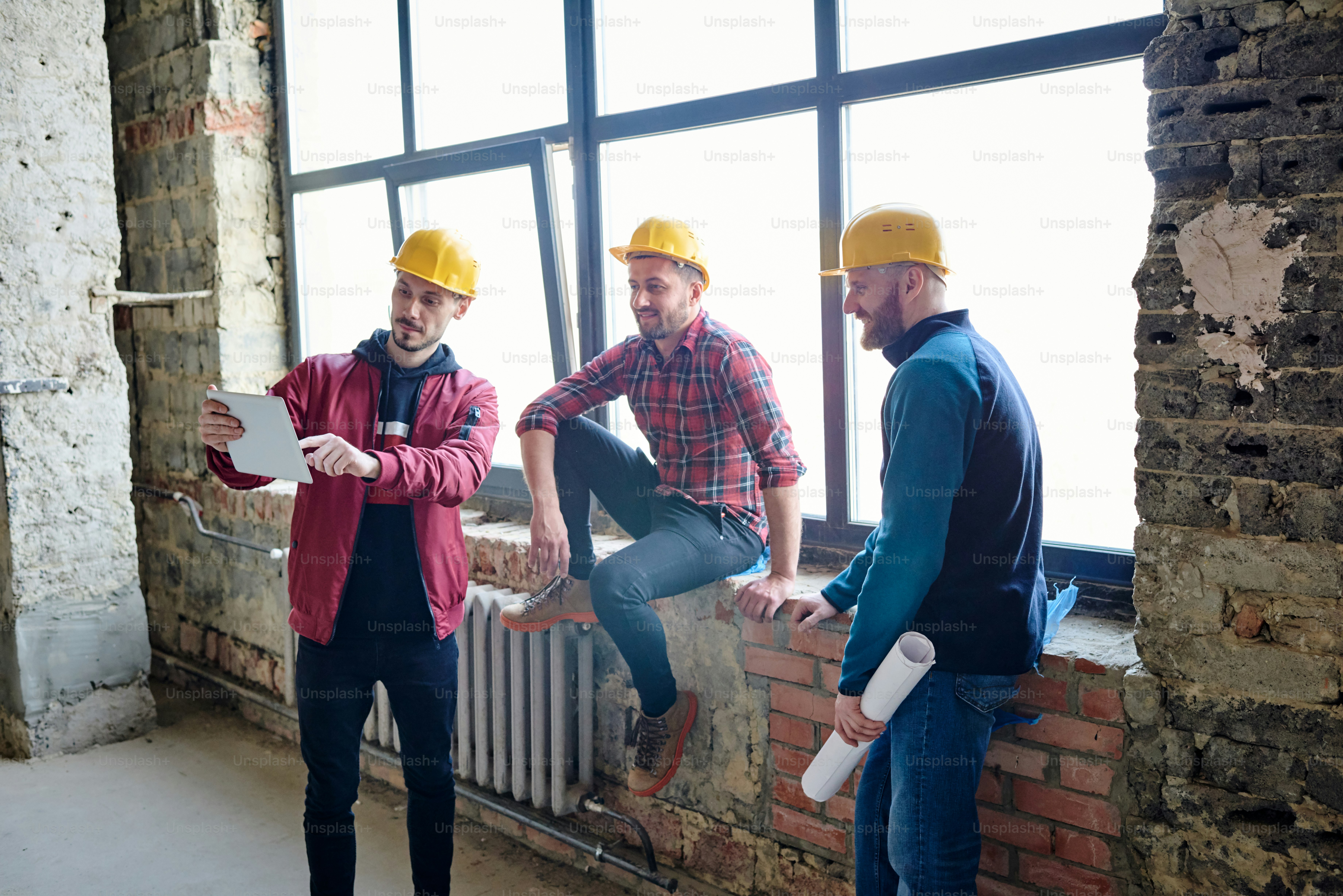 Einer von drei jungen Veredlern, die seinen Kollegen seine neuen Ideen oder Angebote präsentieren, während er das Touchpad vor sich hält