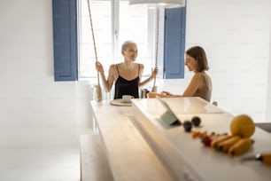 Lesbian couple eating healthy food and have fun at modern studio apartment. Healthy lifestyle, homosexual relations and comfort living at home concept