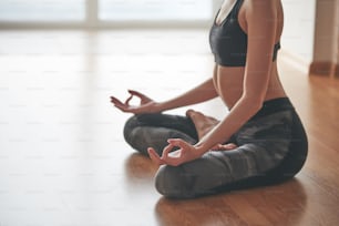 Close up in selective focus of female hands gesture mudra, while doing yoga vinyasa flow, Padmasana, nirvana state of mind