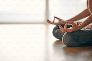 Close up in selective focus of female hands gesture mudra, while doing yoga vinyasa flow, Padmasana, nirvana state of mind